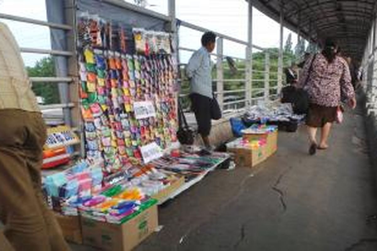 Jembatan penyebrangan orang di Halte Transjakarta UKI Cawang dipenuhi pedagang kaki lima (PKL) yang berjualan di atasnya. Minggu (24/11/2013).