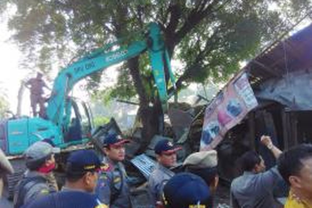 Satu unit alat berat excavator digunakan untuk menggusur kios liar yang berada di jalur hijau jalan raya Pasar Minggu pada Kamis (11/6/2015) pagi