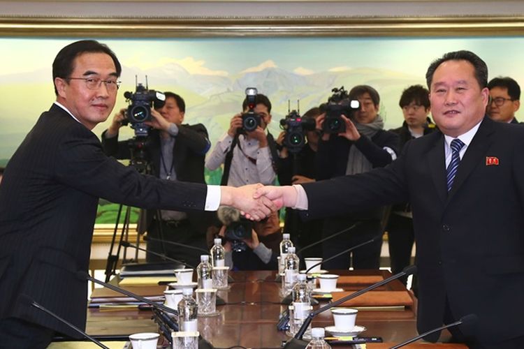 Menteri Unifikasi Korea Selatan Cho Myung Gyun (kiri) berjabat tangan dengan pemimpin delegasi Korea Utara Ri Son Gwon (kanan) dalam pertemuan resmi di Panmunjom, di Zona Demiliterisasi, Selasa (9/1/2018). (AFP/Dong A Ilbo) 