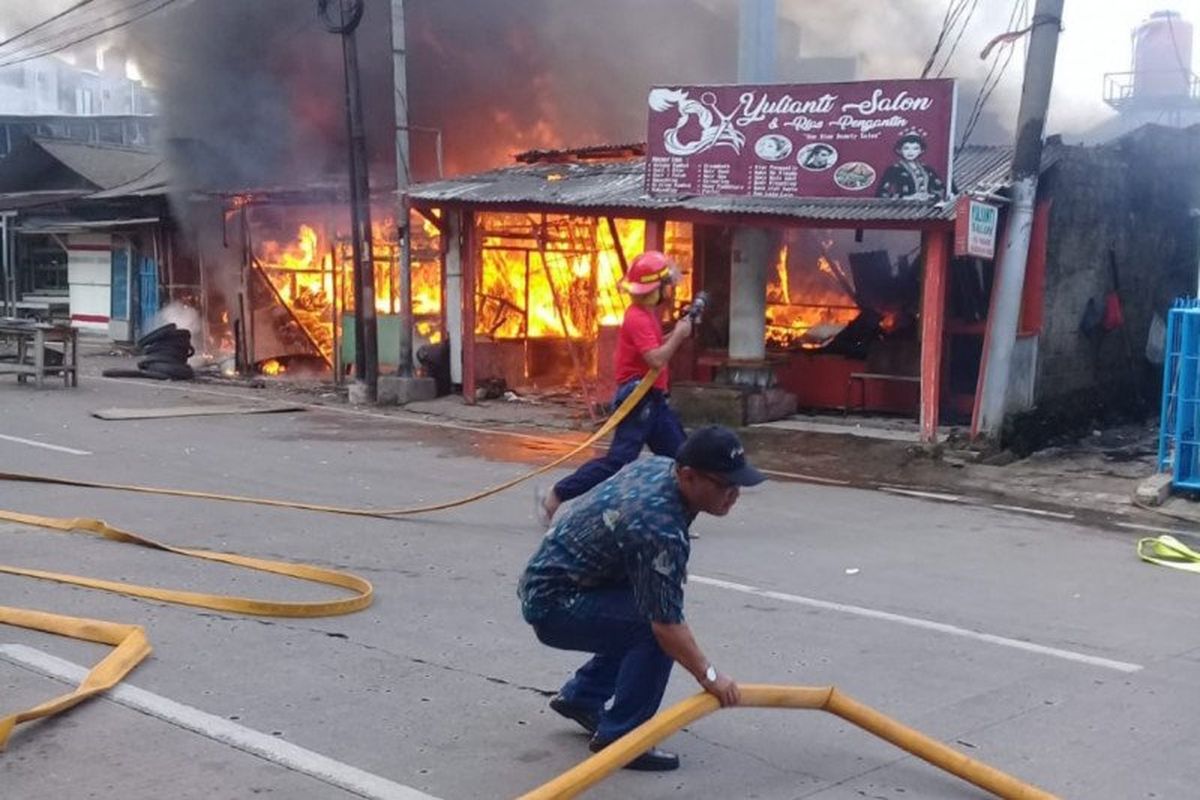 Petugas pemadam kebakaran Jakarta Timur mengarahkan selang pompa semprot menuju bangunan rumah yang terbakar di kawasan Bambu Apus, Cipayung, Jakarta Timur, Minggu (9/2/2020)