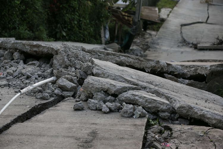 Kondisi kerusakan jalan akibat pergeseran tanah di Kampung Curug, Desa Bojong Koneng, Kecamatan Babakan Madang, Kabupaten Bogor, Jawa Barat, Senin (19/9/2022). Badan Penanggulangan Bencana Daerah (BPBD) setempat mencatat, 71 unit rumah yang mengalami kerusakan 116 orang diungsikan.