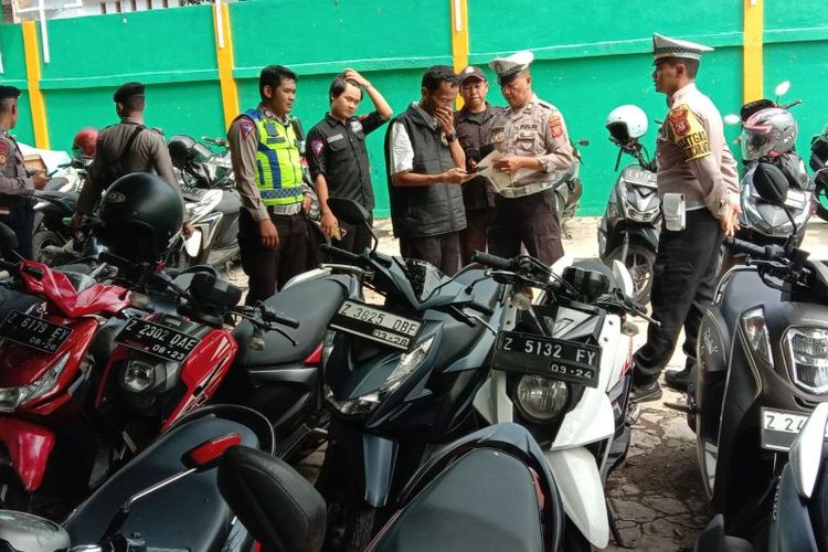 Polisi memeriksa kendaraan sepeda motor untuk menertibkan knalpot bising di lingkungan sekolah di Kabupaten Garut, Jawa Barat.  