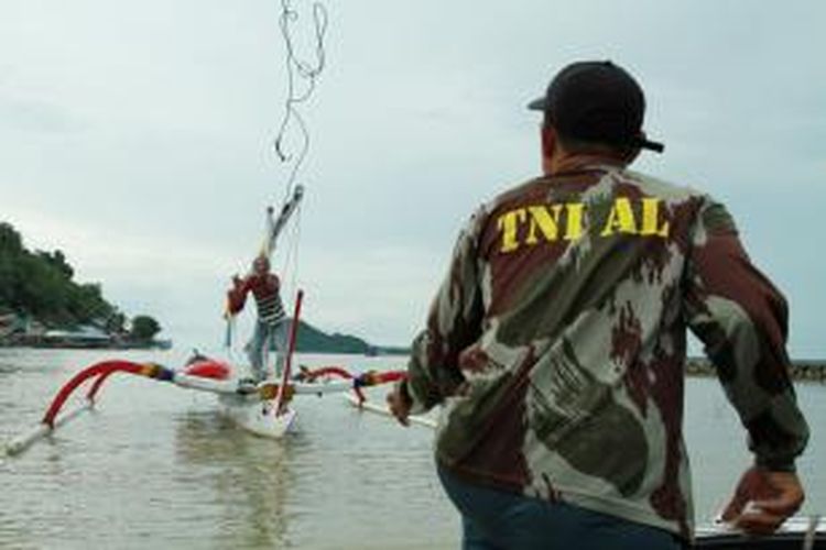 Effendi Soleman sedang melempar tali tambat kepada seorang anggota TNI AL, sesaat setelah dirinya berlabuh di pelabuhan Tanjung Batu Pemangkat, Kabupaten Sambas, Kalimantan Barat (6/9/2013)