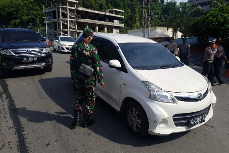 Aparat gabungan menjga jalan di Jembatan Overtom Jl. Samratulangi, Distrik Jayapura Utara, Kota Jayapura. Langkah ini dilakukan sebagai realisasi pembatasan aktifitas masyarakat sejak pukul 14.00 hingga 06.00 wit, Kota Jayapura, Papua, Senin (18/5/2020)