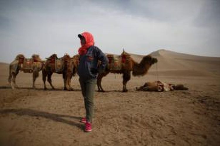 Pemandu wisata di dekat Danau Sabit Yueyaquan di Dunhuang, barat laut Provinsi Gansu, China, 12 Mei 2013. Tempat ini sangat historis. Berada di Jalur Sutra dan menjadi titik pertemuan serta pusat perdagangan kebudayaan timur dan kebudayaan barat.