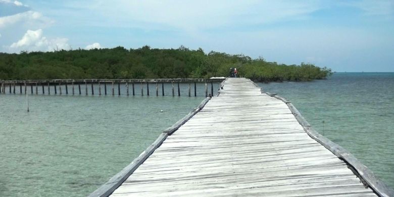 Jembatan kayu yang menghubungkan daratan Pulau Kelapan dengan dermaga kapal. Pulau Kelapan berada di Kabupaten Bangka Selatan, Kepulauan Bangka Belitung.