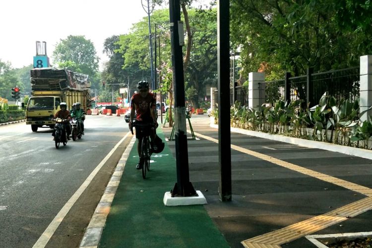 Seorang pesepeda bernama Yupa bersepeda di jalur sepeda trotoar Jalan Asia Afrika, Senayan, Jakarta, Selasa (31/7/2018). Jalur khusus sepeda itu terhalang tiang.