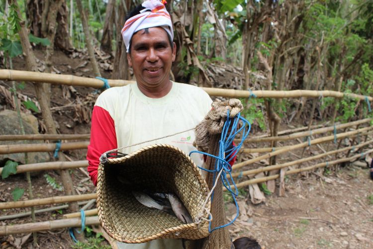 Seorang warga memperlihatkan ikan hasil tangkapannya di ritual Magowo Libu Watu.