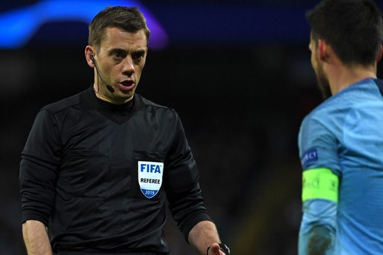 Clement Turpin berbincang dengan David Silva pada laga Manchester City vs Schalke 04 dalam babak 16 besar Liga Champions di Stadion Etihad, 12 Maret 2019. 
