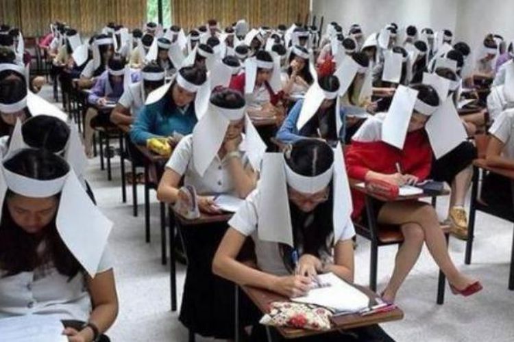 Para mahasiswa di Universitas Kasetsart, Thailand menggunakan penghalang mata untuk mencegah mereka menyontek pekerjaan kawan mereka saat ujian.