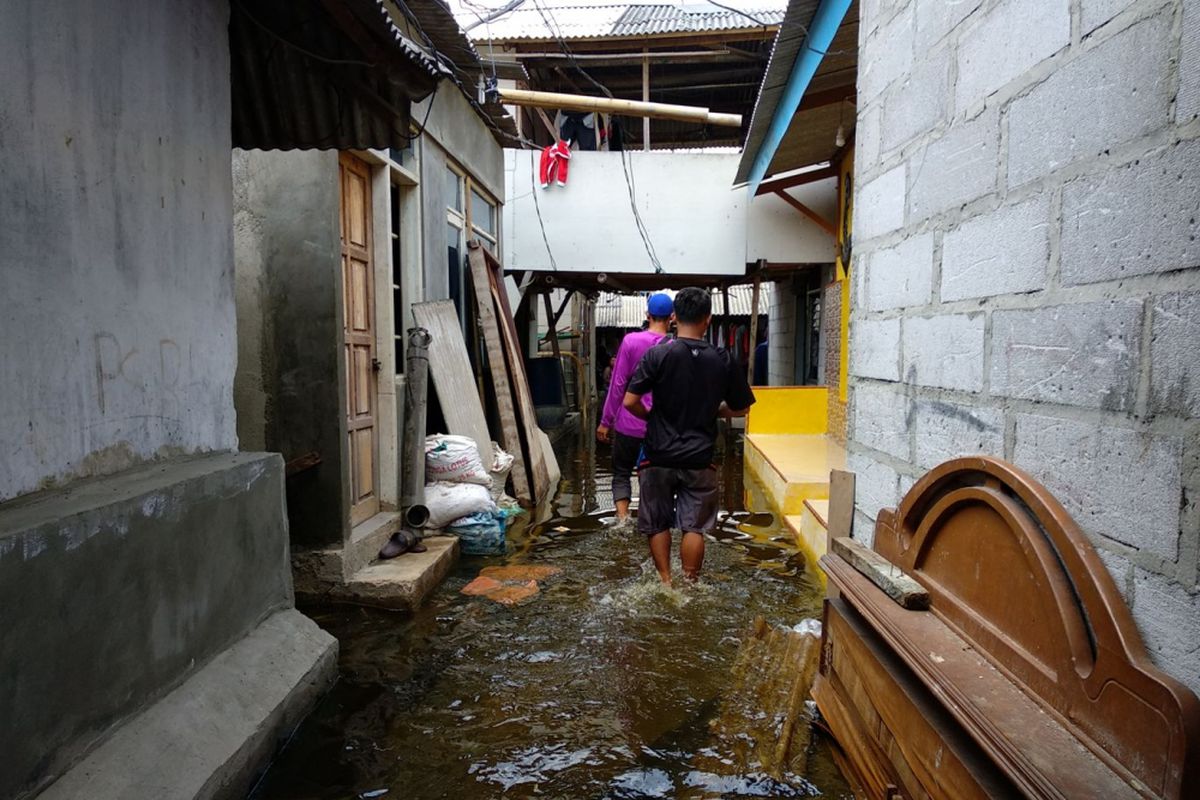Warga melintas genangan banjir rob yang melanda pemukiman di blok Empang, Muara Angke, Rabu (3/1/2018)