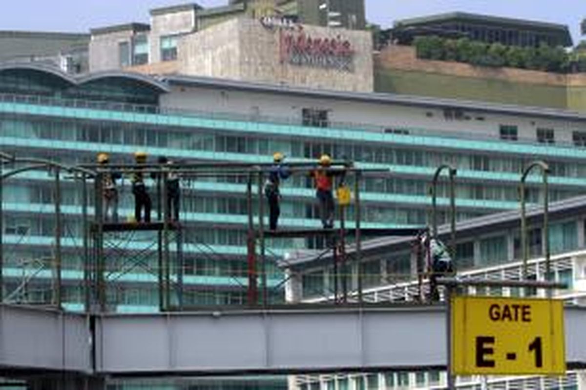 Pekerja menyelesaikan pembangunan jembatan penyeberangan orang (JPO) sementara di sekitar Bundaran Hotel Indonesia (HI), Jakarta Pusat, Jumat (22/8/2014). Pembangunan JPO sementara di depan Plaza Indonesia ini merupakan hasil relokasi dari JPO sebelumnya yang berlokasi di depan Hotel Pullman, akibat dampak dari pembangunan MRT koridor Sisingamangaraja-Sudirman-Bundaran HI yang sedang berlangsung. TRIBUNNEWS/HERUDIN