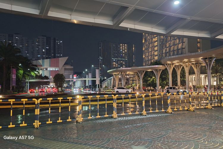 Hasil foto malam Samsung Galaxy A57 5G di area jalan menunjukkan pencahayaan yang seimbang, dengan detail objek seperti kendaraan, bangunan terlihat jelas. 