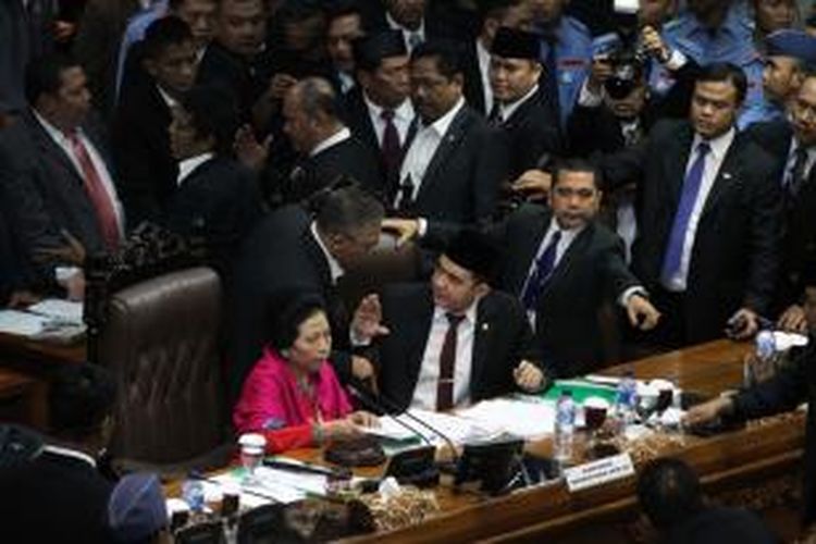 Sejumlah anggota DPR RI maju ke depan memprotes pimpinan DPR RI sementara Popong Otje Djunjunan bersama Ade Rizky Pratama dalam Sidang Paripurna Pemilihan Pimpinan DPR RI di Gedung Parlemen DPR RI, Senayan, Jakarta, Rabu (1/10/2014). Sidang Paripurna yang tidak dihadiri PDI Perjuangan dan PKB tersebut kembali diskors karena sejumlah anggora DPR RI saling berbeda pendapat.  