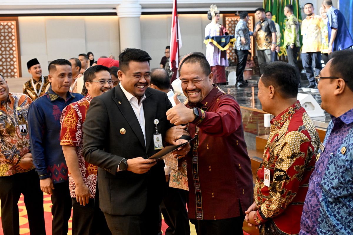 Gubernur Sumatera Utara (Sumut) Bobby Nasution didampingi Sekretaris Daerah Sumut Togap Simangunsong memberikan Dana Bagi Hasil (DBH) kepada Bupati dan Wali Kota Se-Sumut Tahun 2025 di Aula Raja Inal Siregar, Jumat (8/8/2025). 