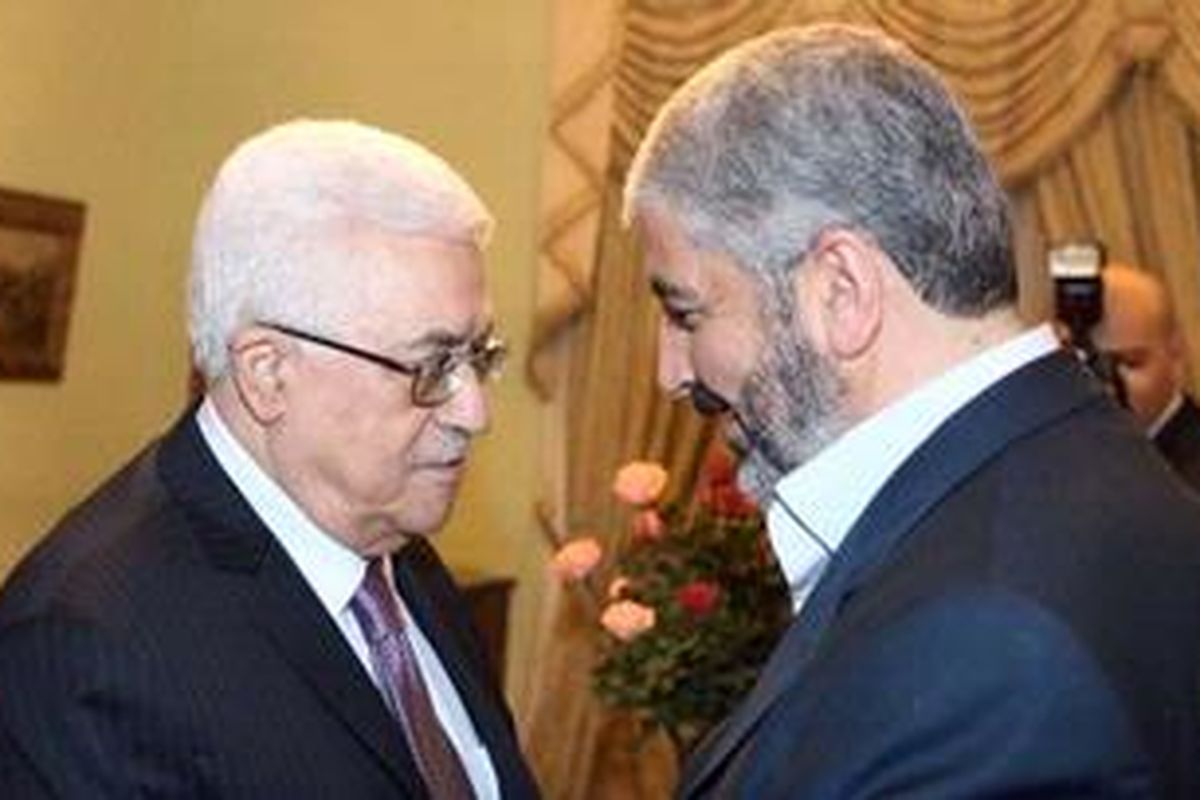 Presiden Palestina Mahmud Abbas (kiri) bersalaman dengan pemimpin Hamas, Khaled Meshaal (kanan) di Kairo, Mesir, Rabu (21/12/2011).