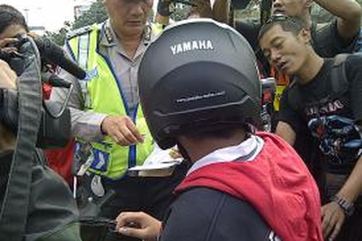 Polisi menilang salah satu pelajar di bilangan Pramuka, Jakarta Timur, Selasa (10/9/2013). Dari razia tersebut, polisi menilang 35 pelajar yang mengemudi tanpa SIM.