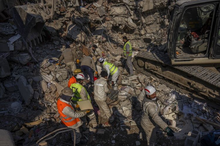 Anggota tim operasi pencarian dan penyelamatan bekerja menggali puing-puing di zona gempa di Antakya, Turkiye, Minggu (12/2/2023).