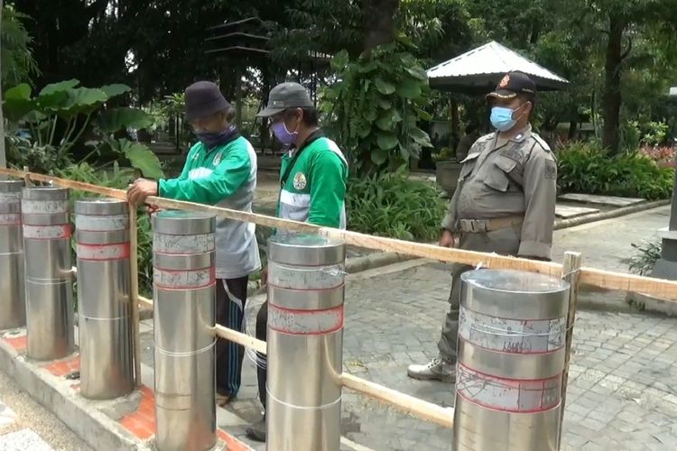 Sejumlah petugas melakukan penutupan akses masuk di lokasi wisata Alun-Alun Kabupaten Tulungagung Jawa Timur beberapa waktu lalu.