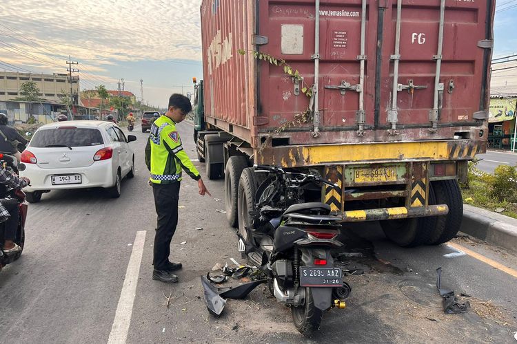 Polisi menunjukkan sepeda motor yang menabrak truk trailer hingga pengendaranya tewas di Jalan Raya Desa Manyarejo, Kecamatan Manyar, Gresik, Jawa Timur, Senin (6/5/2024).