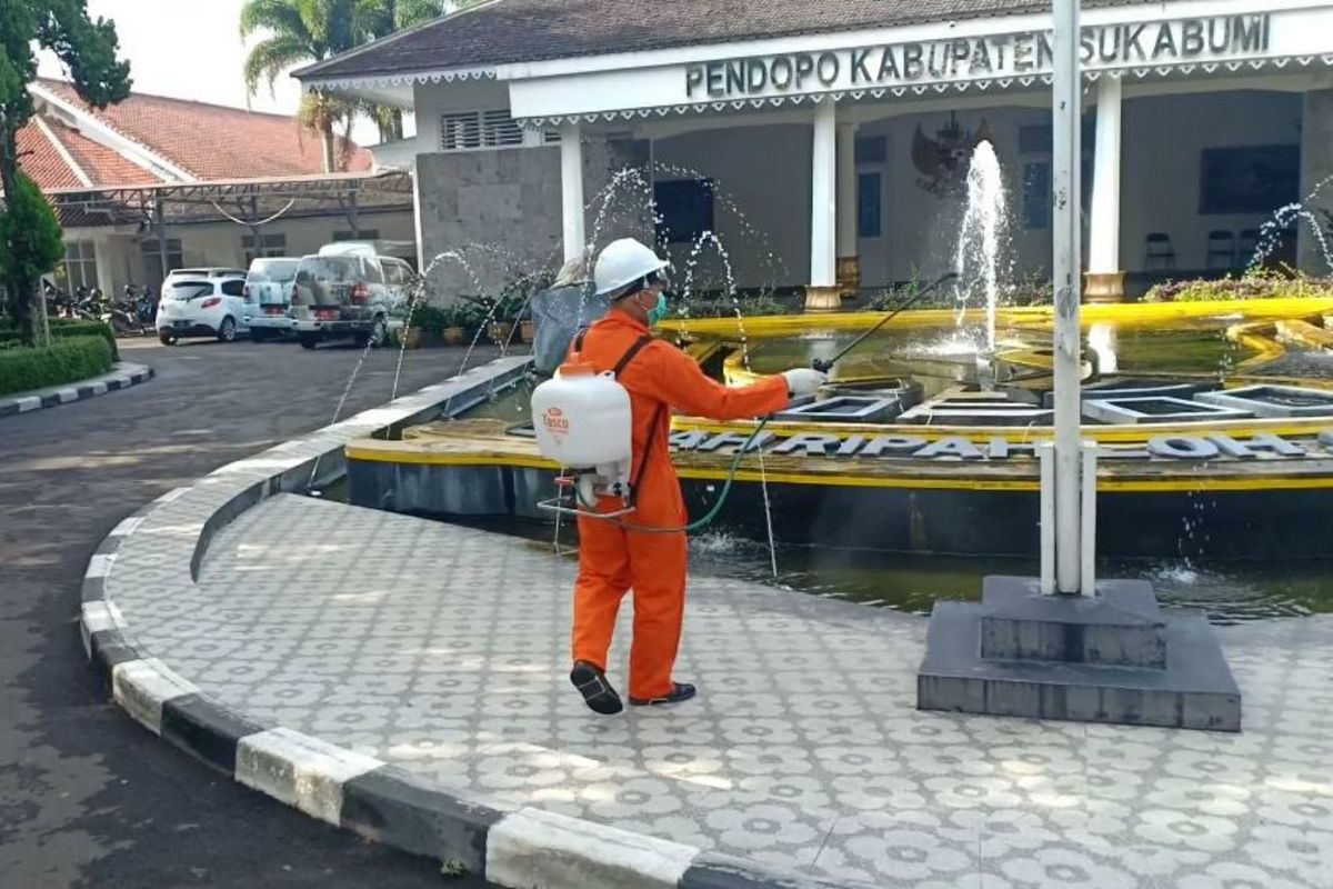 Petugas menyenmprotkan disinfektan di halaman Gedung Pendopo Sukabumi, Jawa Barat, Jumat (20/3/2020).