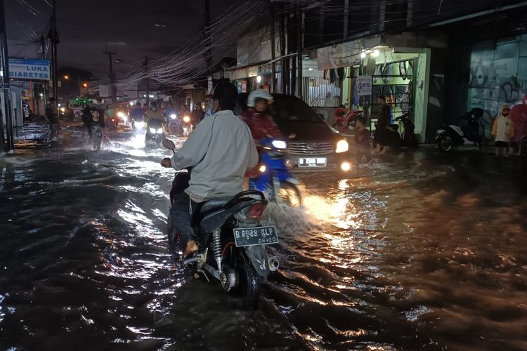 Salah seorang pengendara motor yang mengalami mogok mesin saat sedang menerobos banjir di Jalan Kaliabang Tengah, Bekasi Utara, Kota Bekasi, Kamis (2/6/2022) sore pukul 17.30 WIB. 
