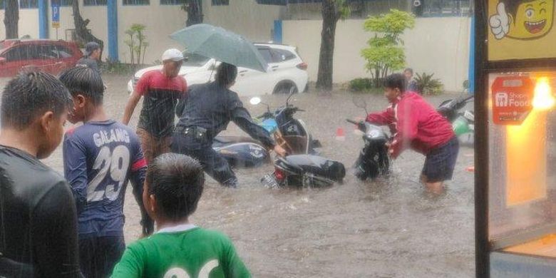 Banjir di Jalan Bujana Tirta akibat debit air hujan deras yang tidak tertampung pada saluran air, Pulogadung, Jakarta Timur, Kamis (6/10/2022) 