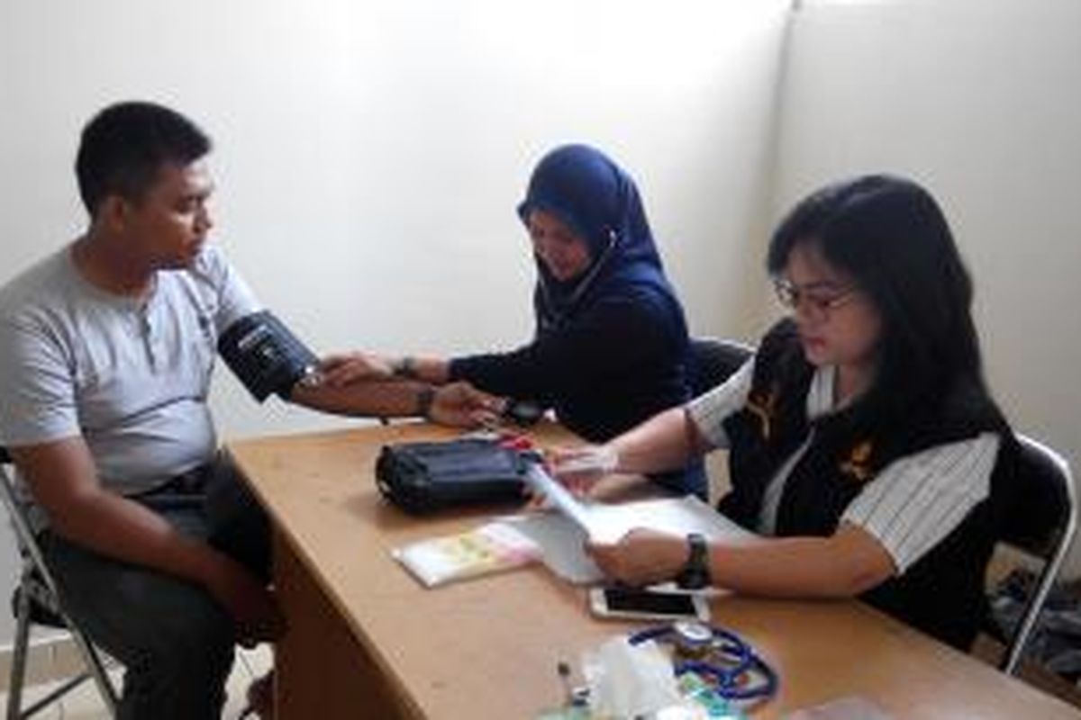 Petugas kesehatan dari Urkes Polres Jakarta Timur, melayani pasien di rusunawa Jatinegara Barat, Jakarta Timur, Minggu (23/8/2015).