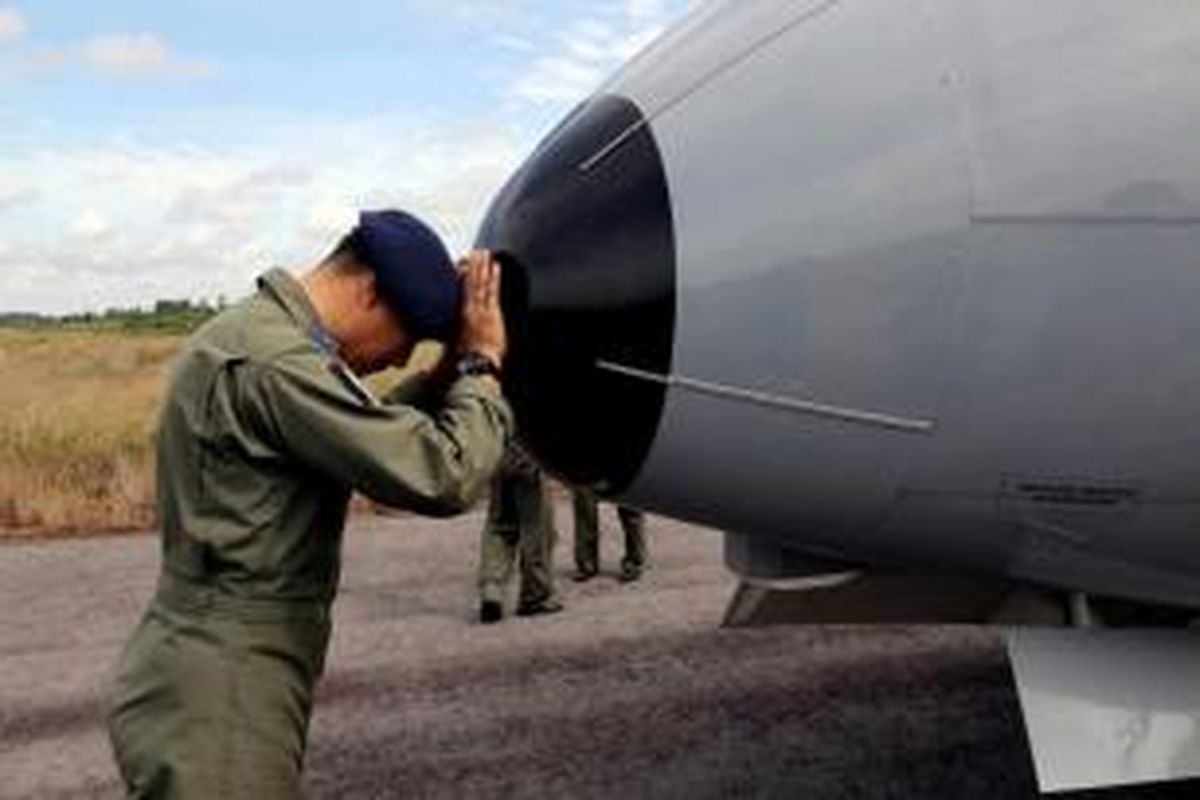 Seorang anggota TNI AL berdoa di hidung pesawat CN-235 saat akan memulai operasi pencarian pesawat AirAsia QZ8501, di Pangkal Pinang, Pulau Bangka, 30 Desember 2014. Pesawat AirAsia QZ8501 mengangkut 155 penumpang serta 7 kru, jatuh pada Minggu pagi, saat penerbangan dari Surabaya ke Singapura.
