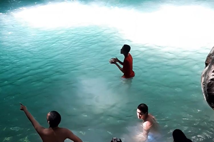 Beberapa wisatawan nampak asyik berenang dan berfoto di kolam pemandian alami di tempat pariwisata Air Terjun Waimarang, Pulau Sumba, NTT.
