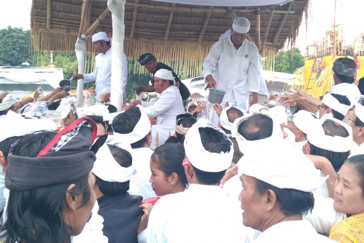 Umat berebut Tirta dan Beras setelah upacara Tawur Kesanga di Lapangan Puputan, Denpasar