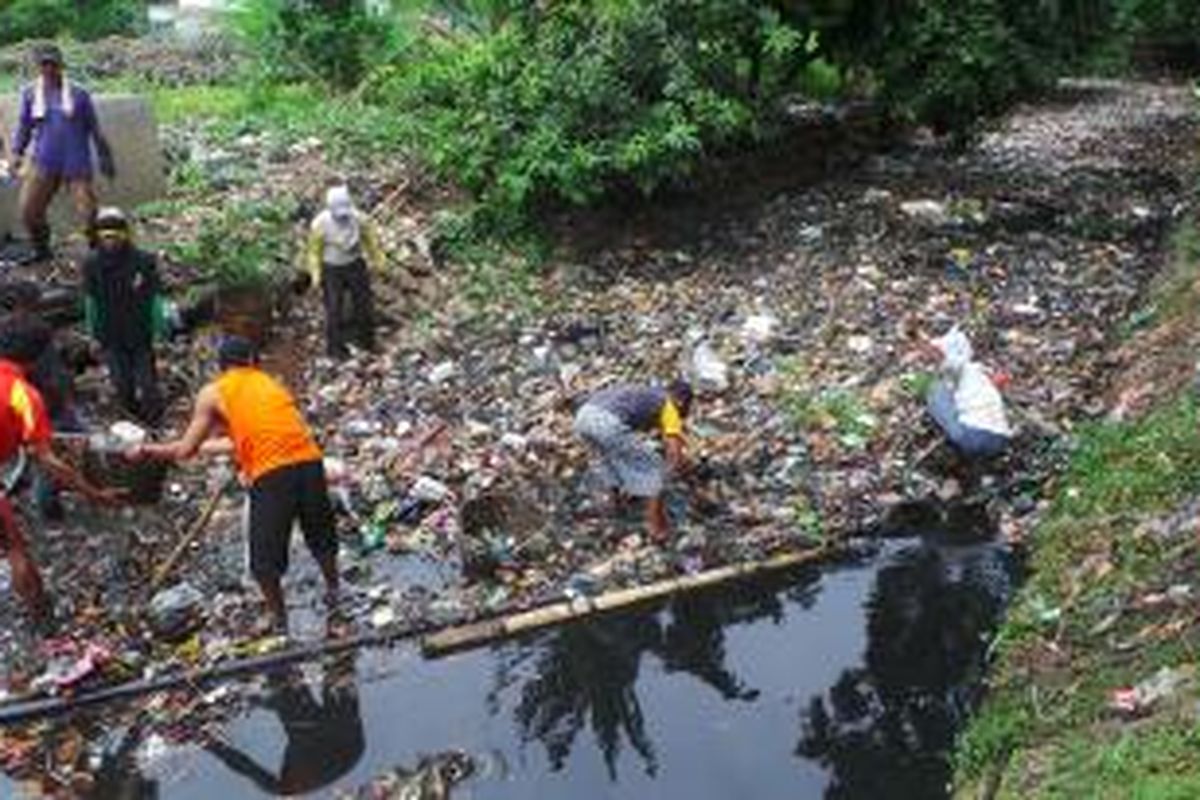 Pekerja membersihkan sampah di ujung pintu air Waduk Bujana Tirta, Pisangan Timur, Pulogadung, Jakarta Timur, Selasa (5/11/2013).