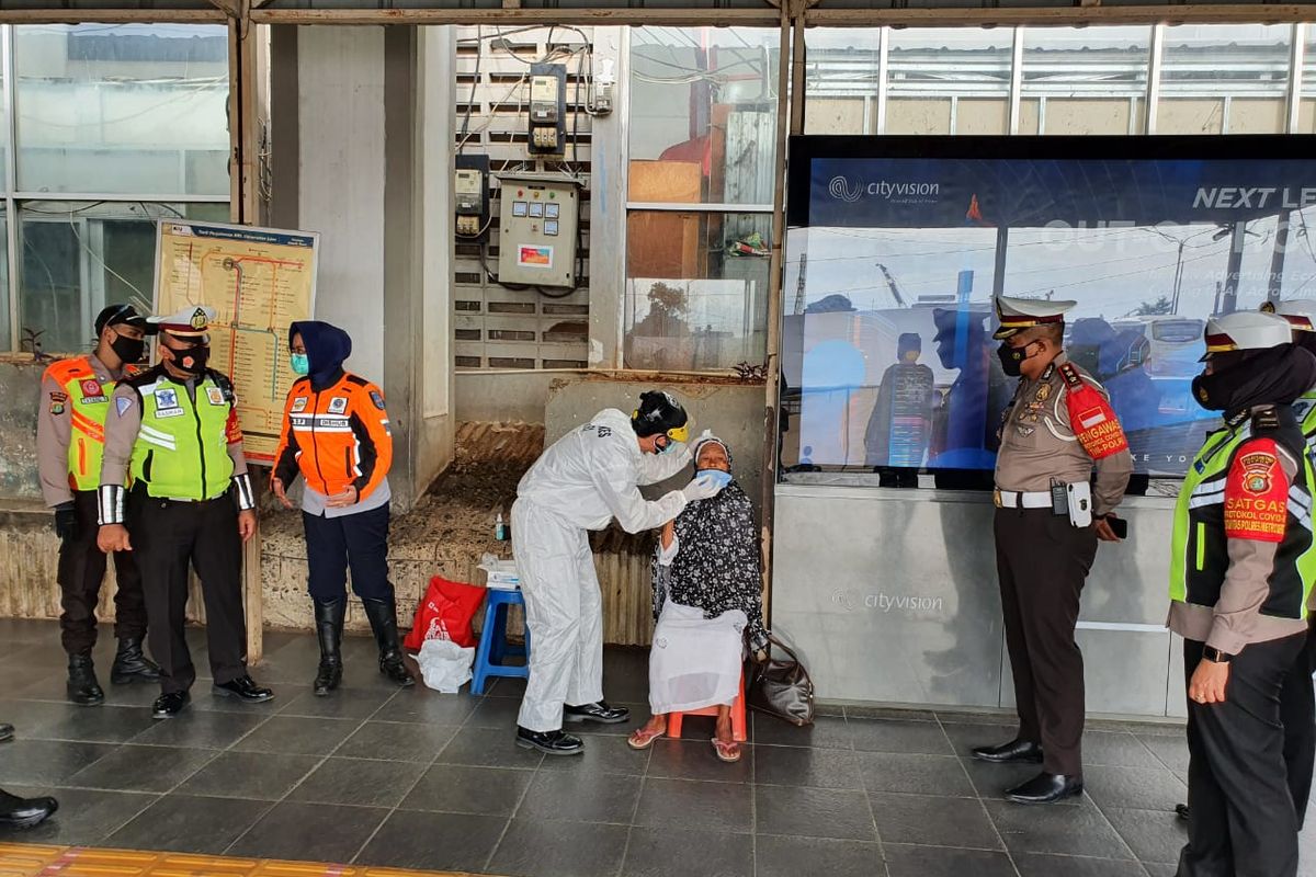 Pembagian masker yang dilakukan Polres Metro Depok kepada salah satu pengguna kereta di Stasiun Depok Baru, Kota Depok, Jawa Barat, Jumat (12/2/2021) siang. 