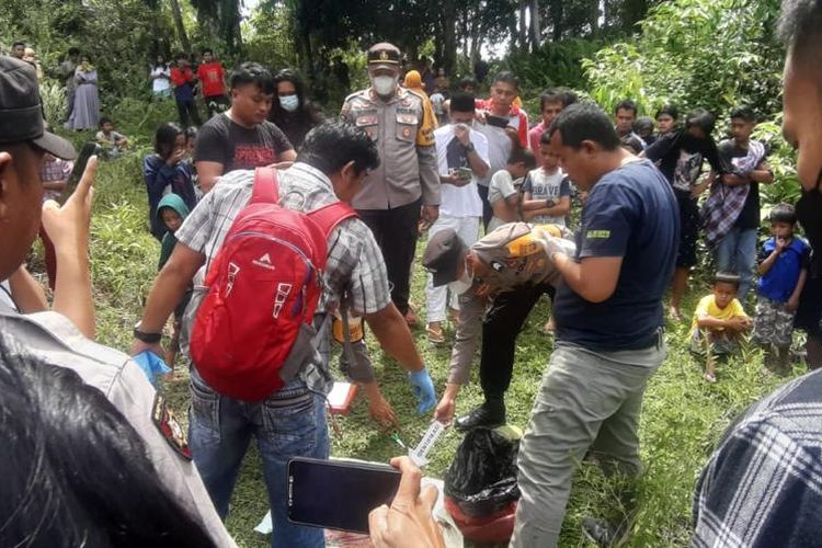 Anggota polisi saat mengevakuasi kantung kresek berisi orok bayi di Kecamatan Mamuju, Kabupaten Mamuju, Sulawesi Barat, Kamis (5/1/2023).