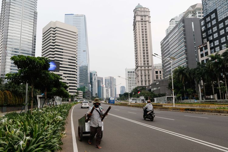 Lalu lintas di Jalan Jenderal Sudirman, Jakarta Pusat pada akhir pekan, Sabtu (18/4/2020). Pemerintah Provinsi (Pemprov) DKI Jakarta resmi menerapkan pembatasan sosial berskala besar ( PSBB) mulai 10 hingga 23 April 2020. Dampak dari adanya aturan ini, membuat kondisi dan situasi lalu lintas pada akhir pekan menjadi lengang dan sepi.