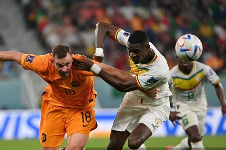 Penyerang Belandan Vincent Janssen (kiri) berduel dengan bek Senegal Pape Abdou Cisse pada laga matchday pertama Grup A Piala Dunia 2022 di Stadion Al Thumama, Qatar, Senin (21/11/2022) malam WIB.