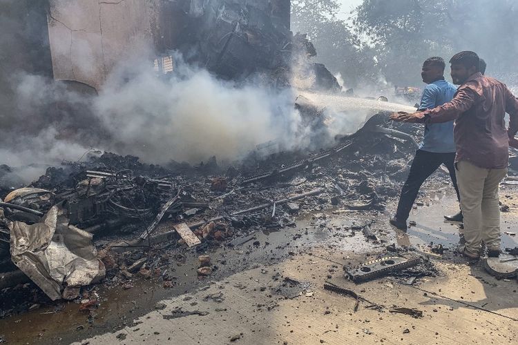Petugas pemadam kebakaran berupaya memadamkan api di lokasi jatuhnya pesawat Air India Boeing 787-8 Dreamliner di kawasan permukiman dekat bandara di Ahmedabad, Kamis (12/6/2025).