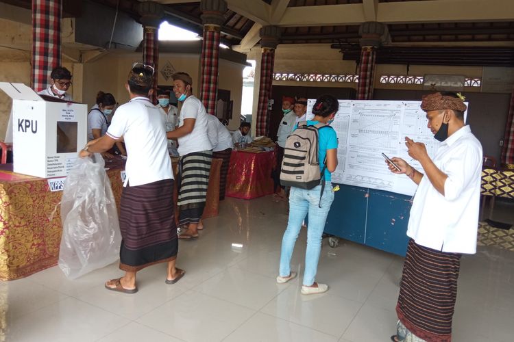 Ilustrasi - Warga melihat hasil perolehan suara saat penghitungan di salah satu TPS di Denpasar, Rabu (9/12/2020).