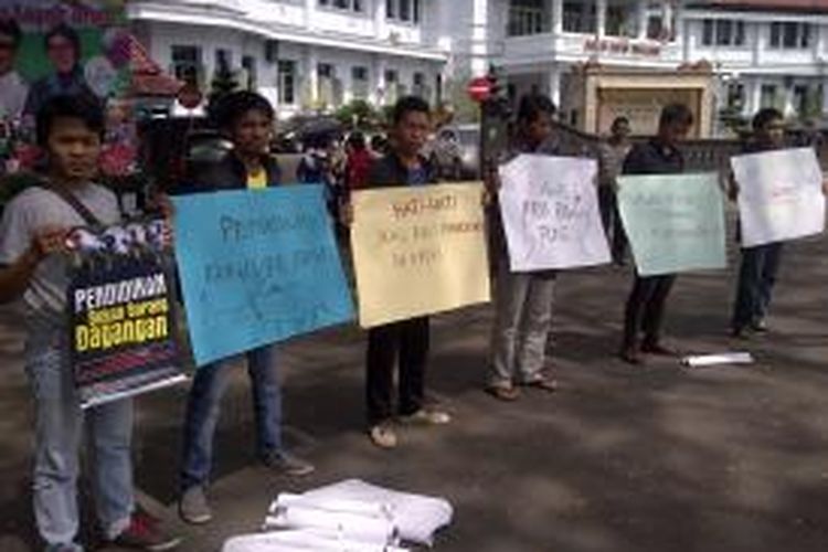 Puluhan aktivis MCW Malang, menggelar aksi diam di depan balaikota Malang, Selasa (16/7/2013) mengecam praktik pungutan liar PPDB di Malang.