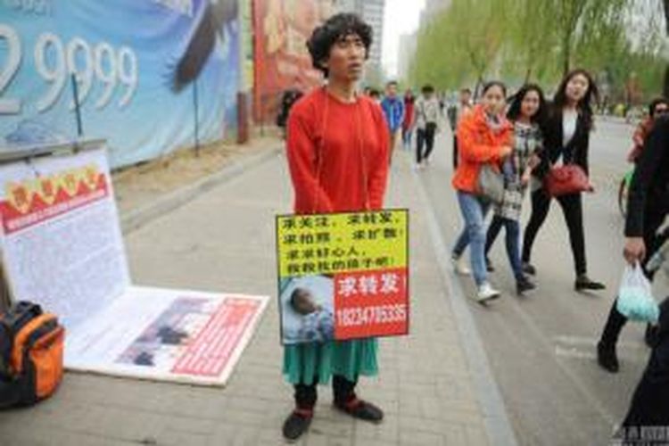 Pria asal Shanxi, China ini setiap pagi berdandan seperti seorang perempuan sambil mengalungkan foto putranya yang menderita leukemia. Dia melakukan hal ini demi mengumpulkan dana untuk biaya pengobatan putranya  itu.