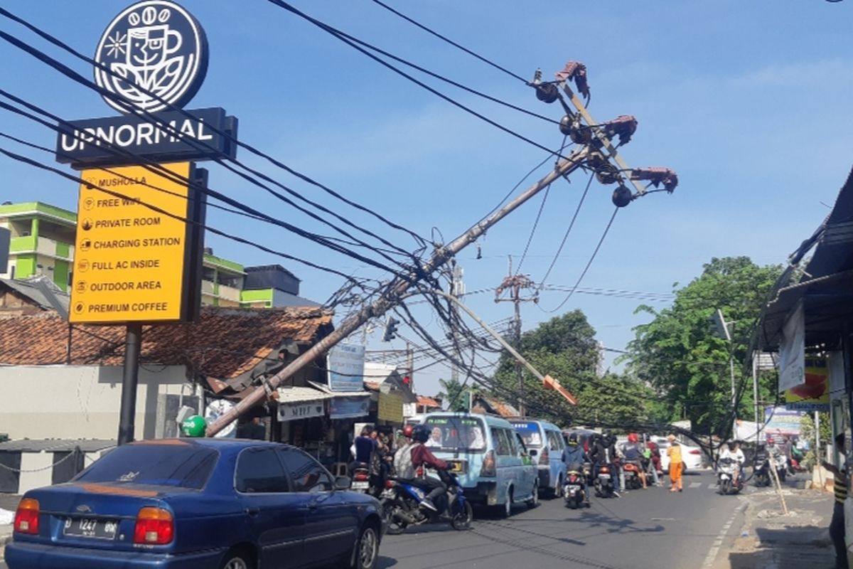 Tiang listrik roboh dan hampir jatuh ke jalan di Jalan Raya Kebon Jeruk, Jakarta Barat, Senin (21/10/2019).