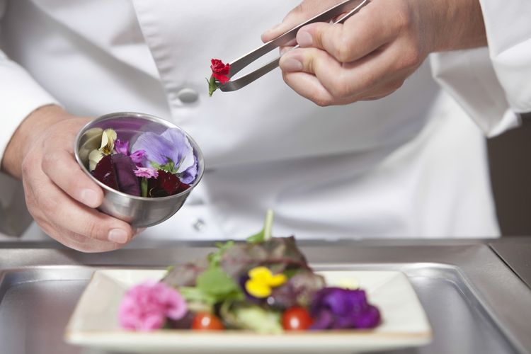 Ilustrasi chef menggunakan edible flowers dalam makanan