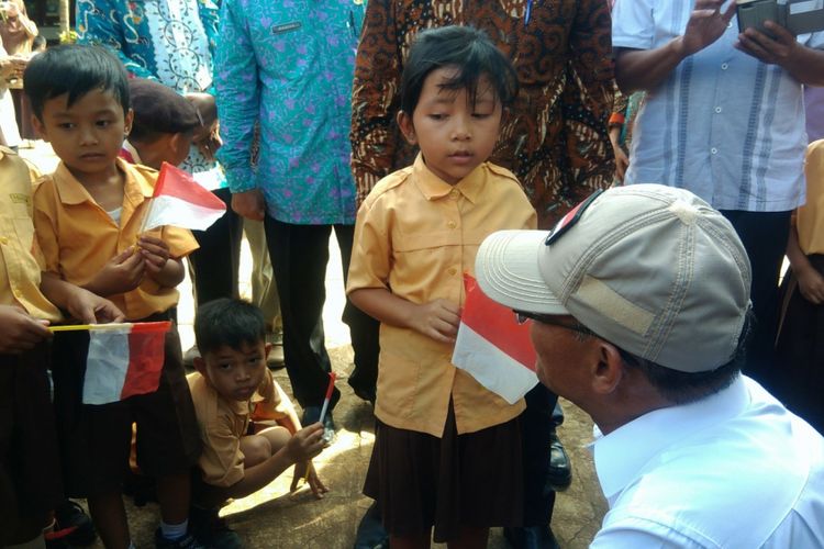 Menteri Pendidikan dan Kebudayaan Muhadjir Effendy antusias mendengarkan siswi Sekolah Dasar Negeri Gunung Kunir 01, Desa Pacarejo, Semanu, Gunungkidul, saat menghafal sila Pancasila.