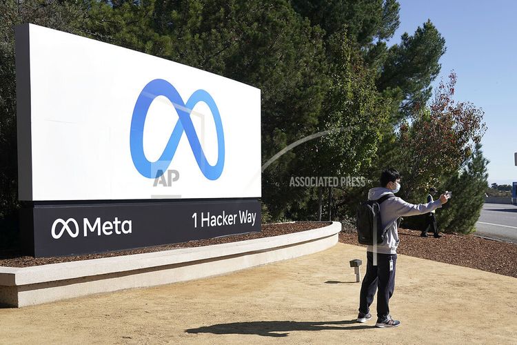 Seorang karyawan Facebook terlihat sedang selfie di depan logo perusahaan Meta yang berlokasi di Menlo Park, California, AS pada Kamis (28/10/2021).