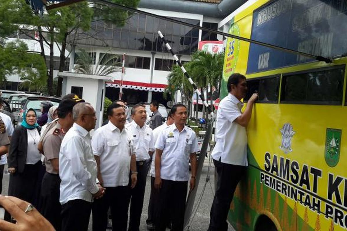 Menteri Pendayagunaan Aparatur Negara dan Reformasi Birokrasi Asman Abnur (paling depan) berbincang dengan petugas Samsat Keliling di Pekanbaru, Rabu (7/9/2016). Salah satu tujuan kedatangan Asman ke Riau, adalah memberikan pertimbangan terhadap kesiapan Polda Riau naik kelas menjadi tipe A.  