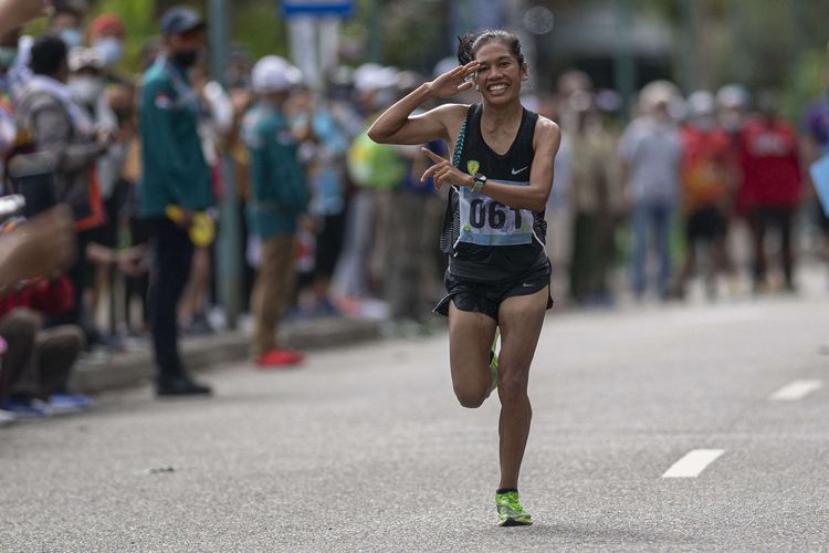 Atlet DKI Jakarta Odekta Elvina Naibaho melakukan hormat saat akan finis dalam nomor lari maraton putri PON XX Papua di kompleks Freeport, Kuala Kencana, Kabupaten Mimika, Papua, Sabtu (9/10/2021). Odekta Elviani berhasil meraih medali emas, sementara pelari putri DKI Jakarta lainnya Tryaningsih meraih medali perak dan pelari putri Kalimantan Timur Irma Handayani meraih medali perunggu.