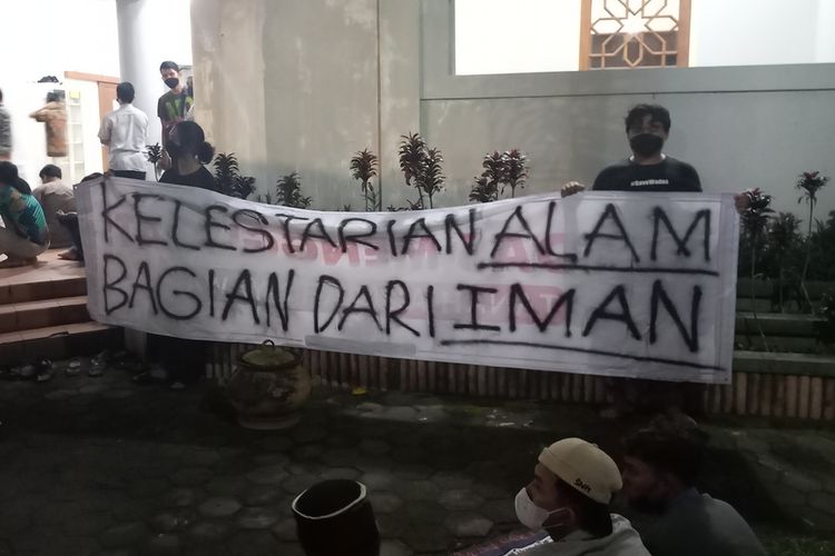 Sejumlah orang membentangkan spanduk sebagai aksi solidaritas untuk warga Wadas saat Gubernur Jawa Tengah Ganjar Pranowo datang ke Masjid UGM, Rabu (6/4/2022)