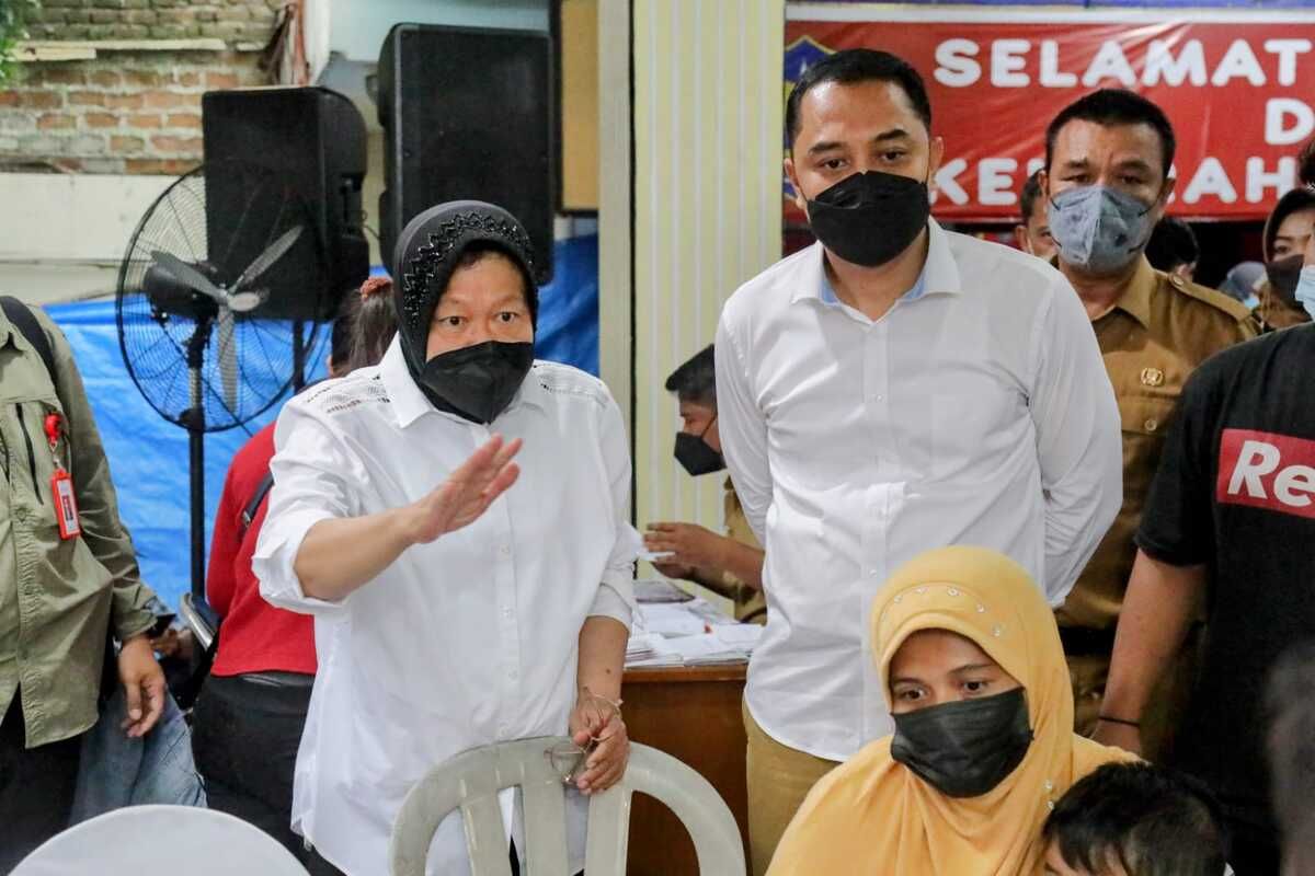 Menteri Sosial Tri Rismaharini bersama Wali Kota Surabaya Eri Cahyadi saat memberikan bantuan di Kelurahan Pakis, Surabaya, Jawa Timur, Senin (27/12/2021).