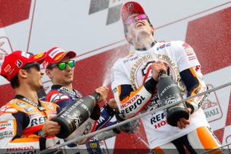 Pebalap Spanyol, Dani Pedrosa (kiri) dan Jorge Lorenzo (tengah) menyemprot Marc Marquez dengan sampagne di podium GP Valencia, Minggu (10/11/2013).