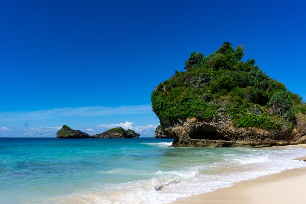 Pantai Srau di Pringkuku, Pacitan, adalah destinasi populer dengan pasir putih halus, air biru jernih, dan pemandangan perbukitan karang, sering disebut sebagai 